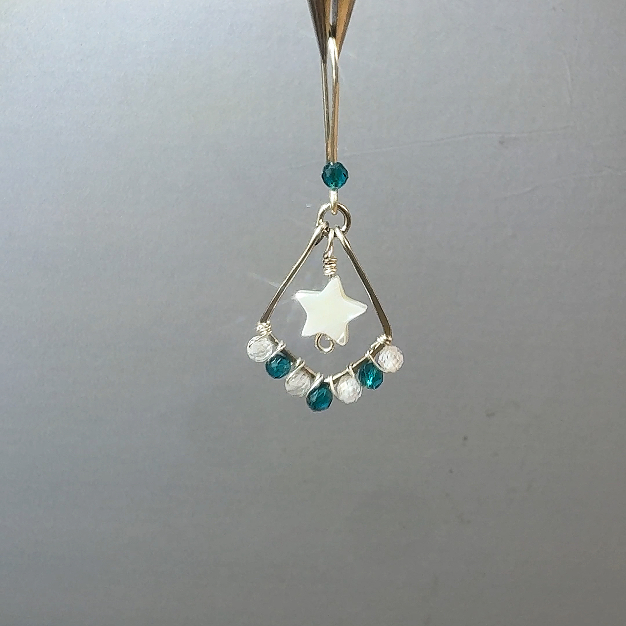 Handcrafted teal star earring close-up