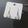 Teal star earrings on display card