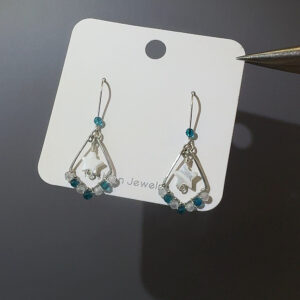 Teal star earrings on display card