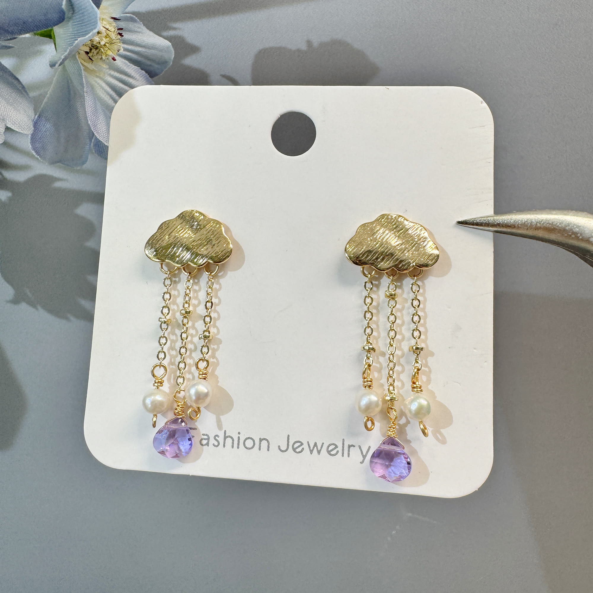 Gold cloud amethyst and pearl tassel earrings displayed as a pair