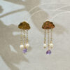 Pair of gold cloud earrings with pearl and purple gemstone drops