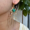 Gold green stone and pearl tassel earring worn on the ear