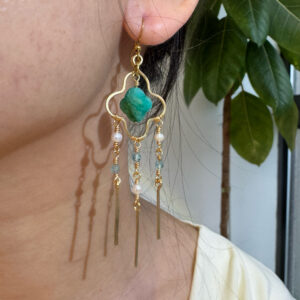 Gold green stone and pearl tassel earring worn on the ear