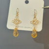 Close-up of gold wire filigree and golden quartz teardrop earrings