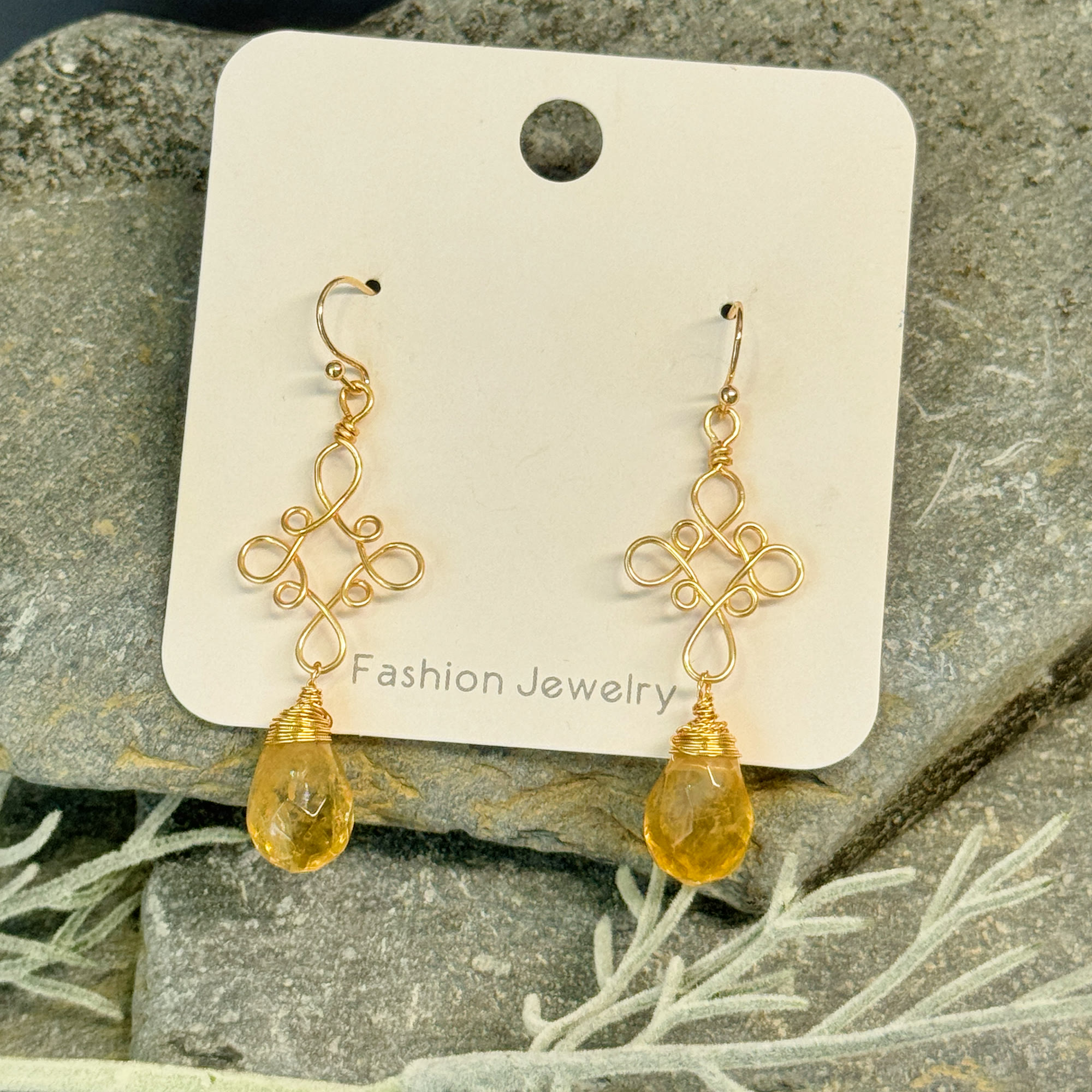 Pair of gold filigree earrings with faceted golden teardrop stones
