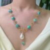 Gold clover baroque pearl necklace worn on model
